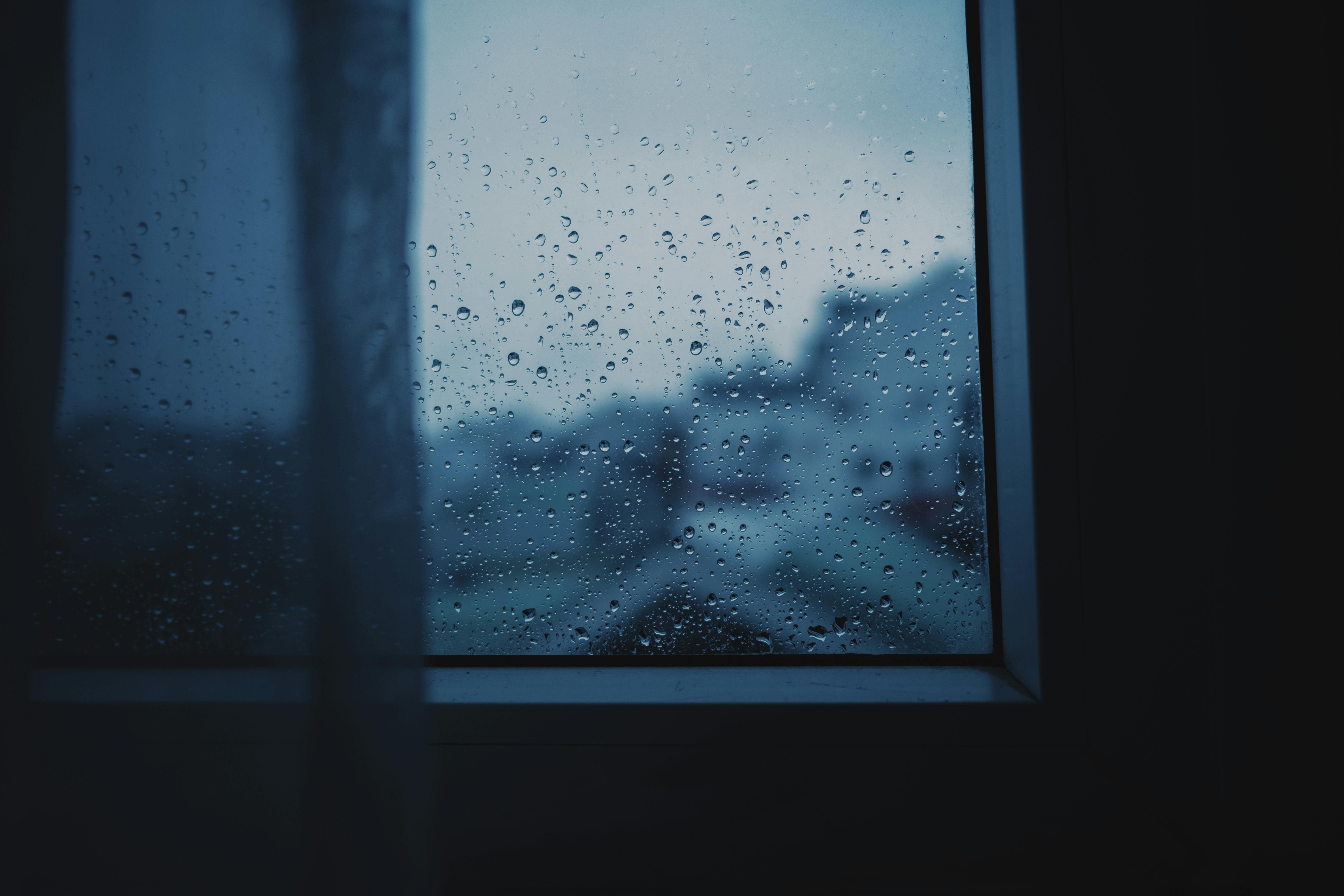 A moody view through a window with raindrops, capturing the essence of a rainy day.
