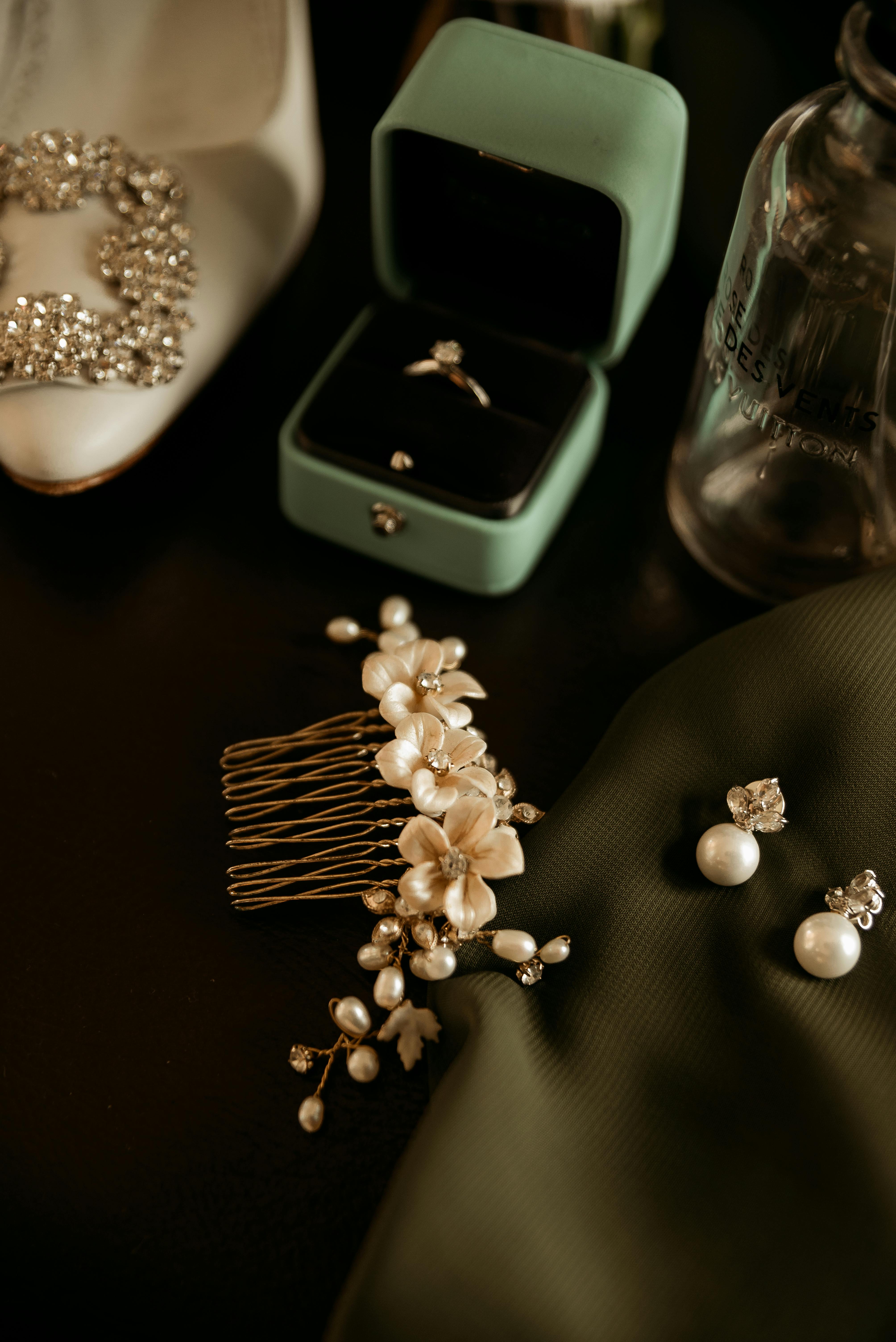 a wedding dress shoes and jewelry are laid out on a table