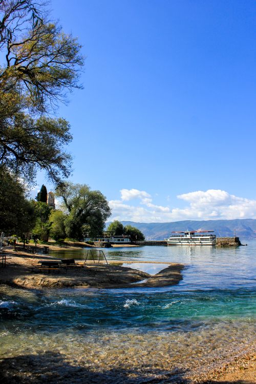 Free Tranquil scene of Lake Ohrid featuring ferries at the harbor and a serene shoreline. Stock Photo