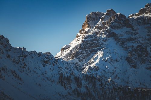 Free Scenic view of snow-covered mountains with rugged peaks against a clear blue sky. Stock Photo