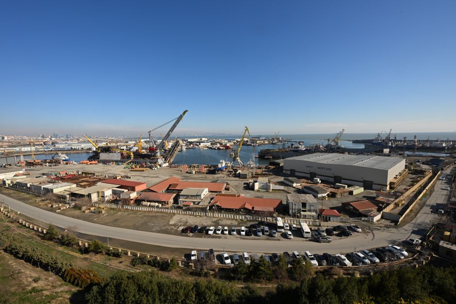 Aerial view of Baku's bustling harbor and shipyard under clear blue skies.