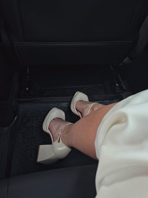 Ankle Strap Block Heels on the Legs of a Model Sitting in a Car