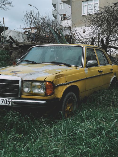 Free Old yellow car in an overgrown backyard in İstanbul, Türkiye, exuding vintage charm. Stock Photo