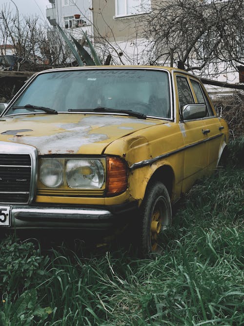Rusty Yellow Car on Grass