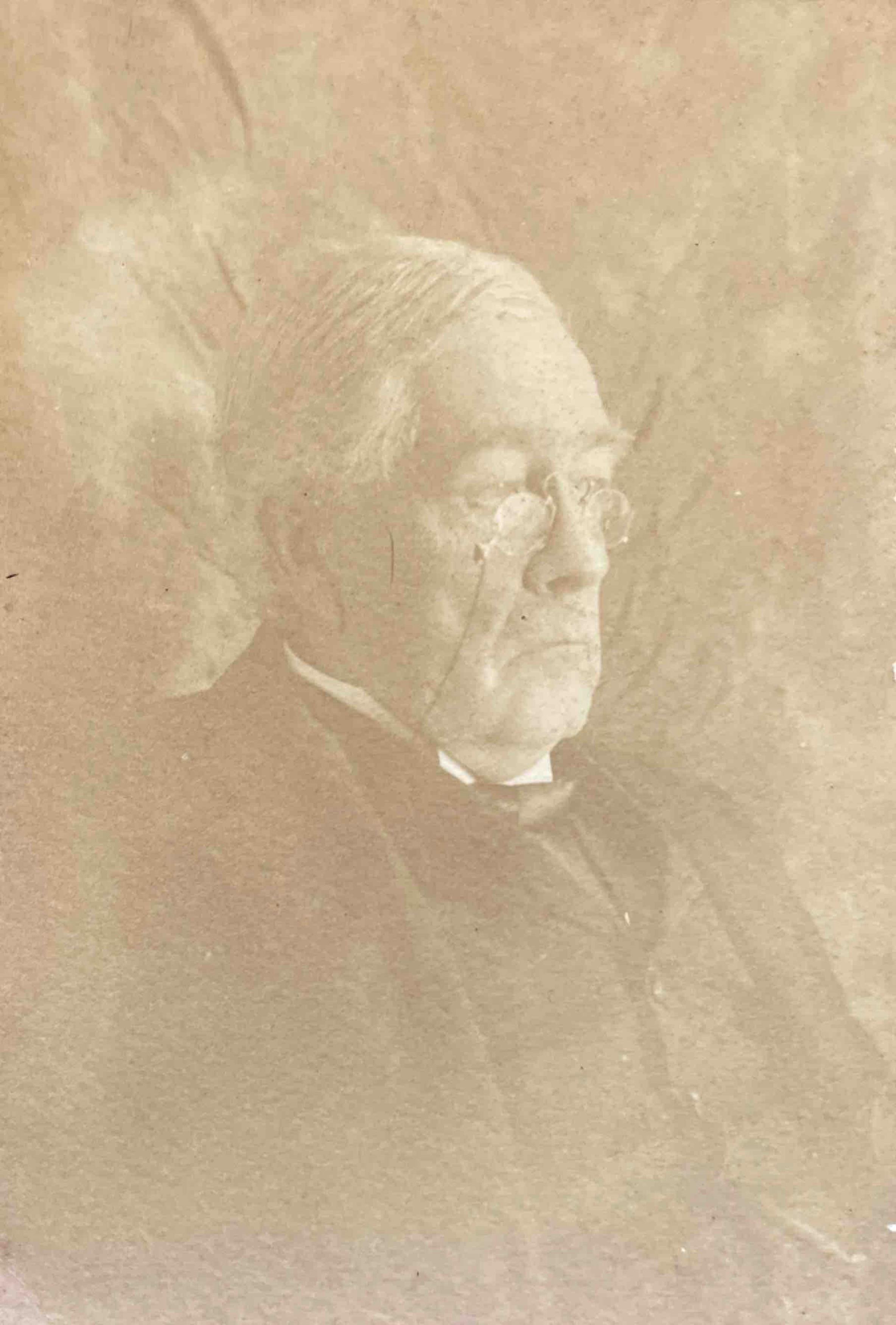 Classic sepia portrait of an elderly man with glasses, exuding a vintage atmosphere.