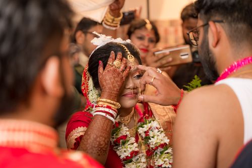 Free A vibrant Indian bride with henna tattoos during a traditional ceremony, adorned with jewelry. Stock Photo