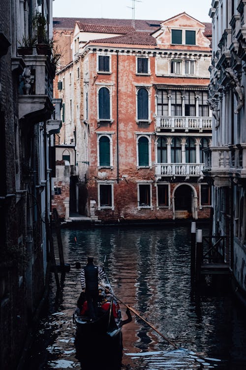 Gondolier Carrying Tourists Through a Narrow Canal
