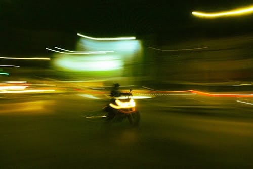 Speeding Motorcyclist Among Blurry Lights