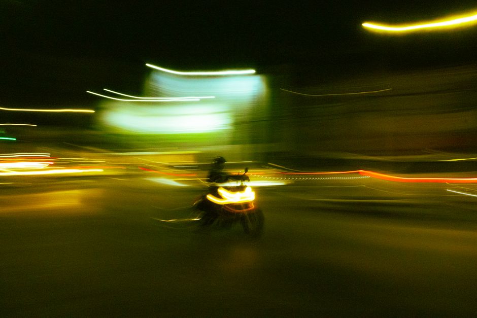 A motorbike speeding through Puebla city streets at night, capturing the dynamic blur of urban motion.
