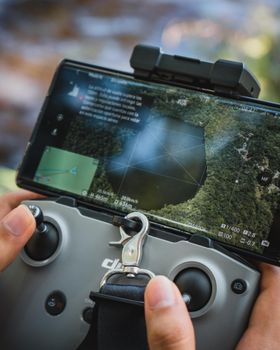 Close-up of a drone controller screen showing an aerial view of a forest in Rioja, San Martín, Perú.