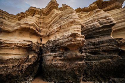 Layered sandstone bedding in an arid canyon — photo by Sina Rezakhani on Pexels