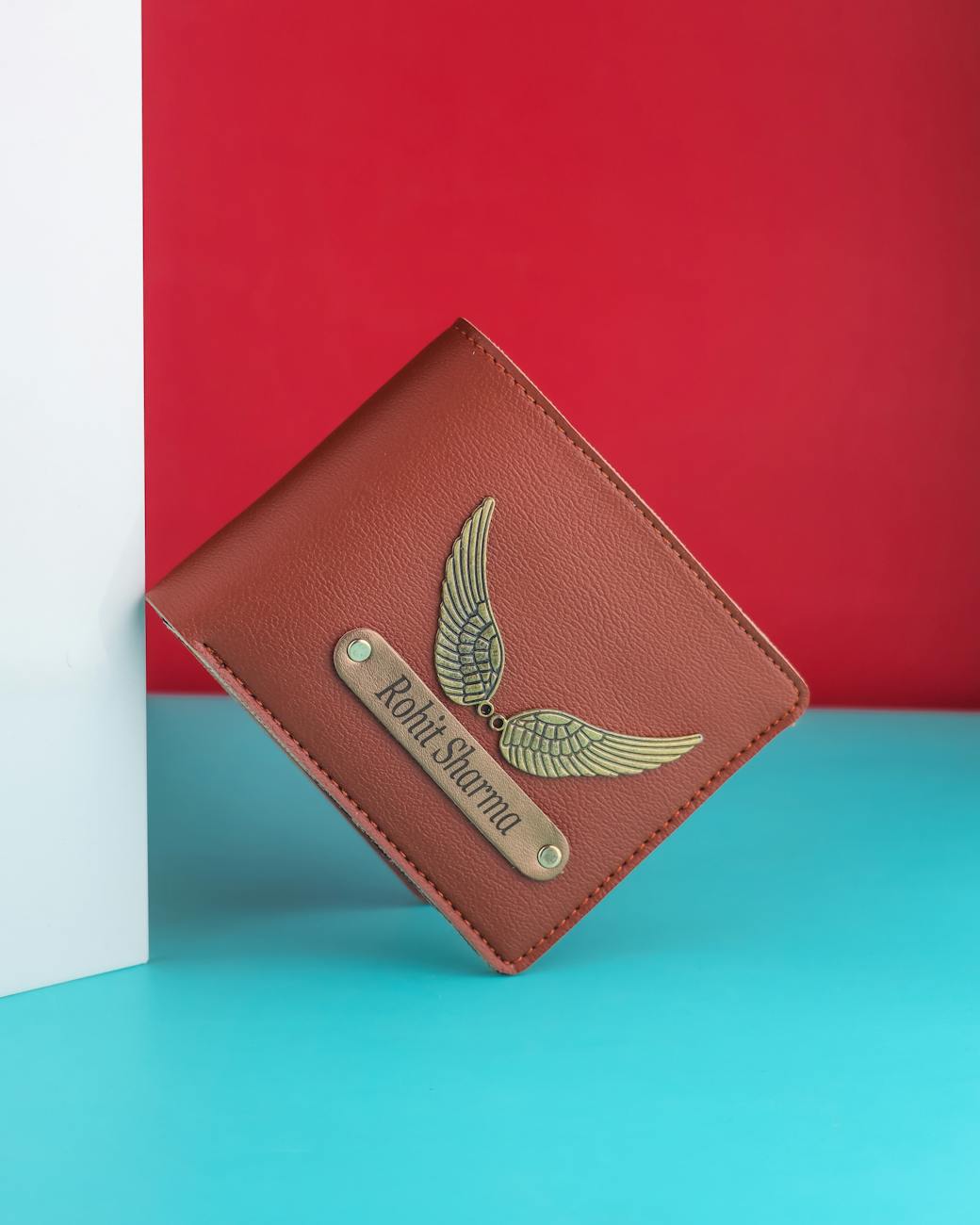 Stylish brown leather wallet featuring a metallic wing design and personalized nameplate.