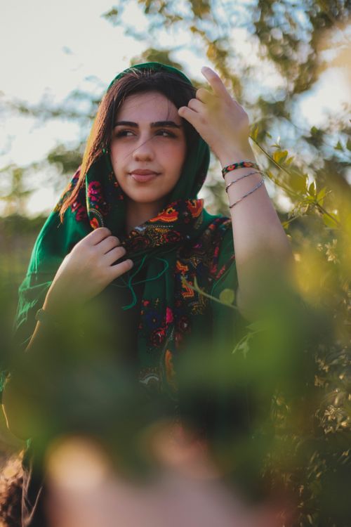 Free Captivating portrait of a young woman in a vibrant headscarf surrounded by natural greenery in Istanbul. Stock Photo
