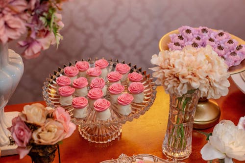 Sweet Cakes on Table with Flowers