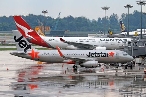 Free Commercial airplanes from Jetstar and Qantas on runway, perfect for travel stock photos. Stock Photo