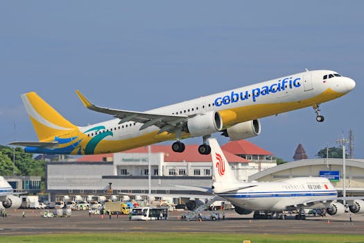 A commercial aircraft from Cebu Pacific takes off at a busy airport, showcasing travel and aviation dynamics.