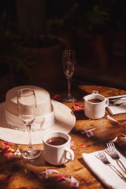 A warm rustic table setting featuring coffee cups, a hat, petals, and rustic cutlery in Oaxaca, Mexico.