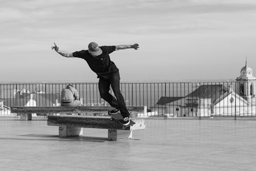 Black and white photo of a skateboarder doing a trick in a Lisbon urban setting.