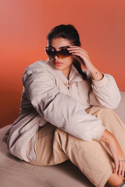 Studio Shot of a Young Woman Wearing a Jacket and Sunglasses