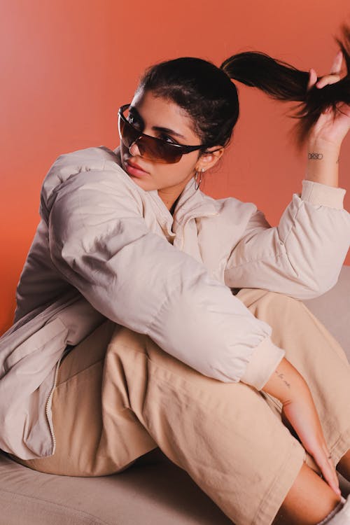 Studio Shot of a Young Woman Wearing a Jacket and Sunglasses