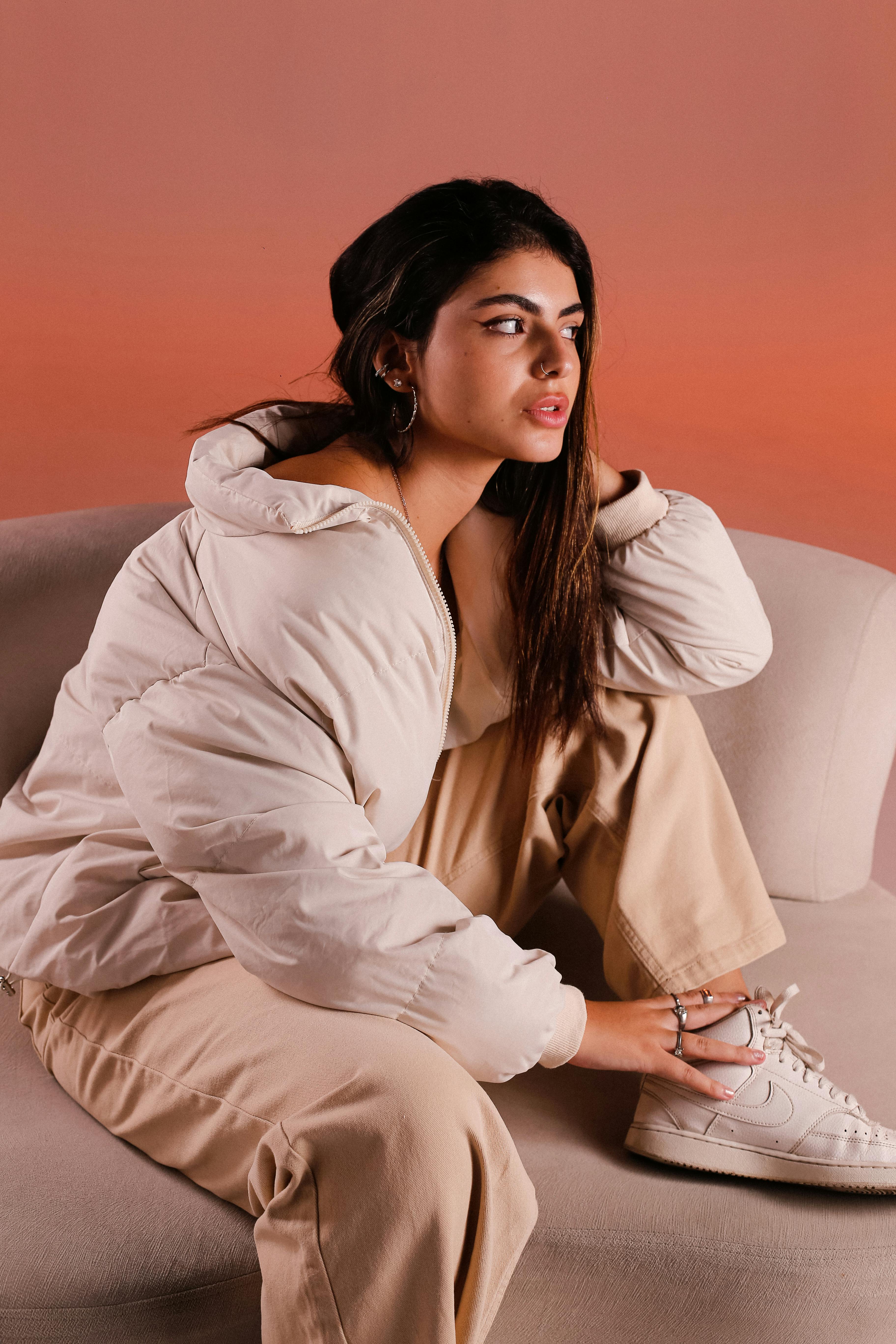 Young woman in fashionable attire posing indoors with a trendy jacket.