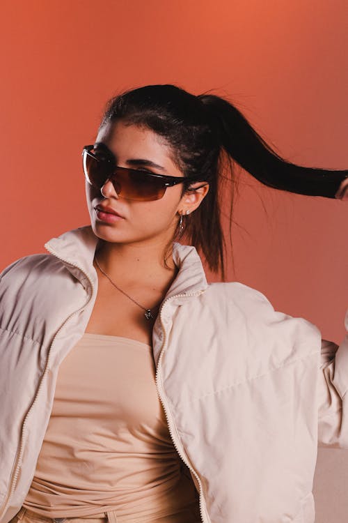 Studio Shot of a Young Woman Wearing a Jacket and Sunglasses