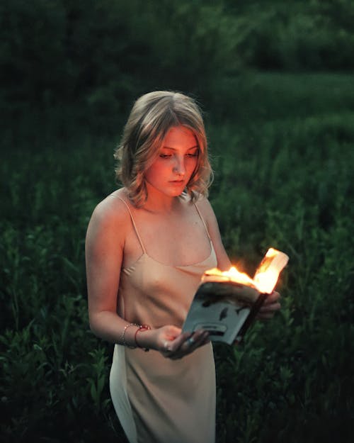 Free Woman Reading a Burning Book Stock Photo