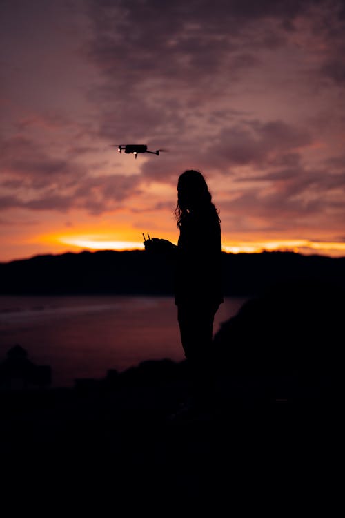 Person Steering Drone at Sunset