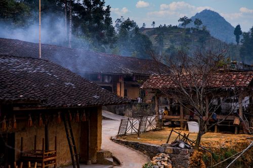 Free Charming rural village scene featuring traditional houses and scenic hilly background. Stock Photo