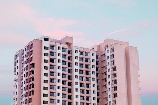 A low angle view of a modern high-rise office building against a pastel sky at dusk.
