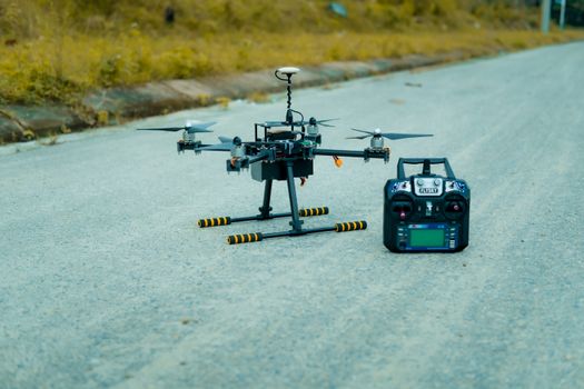 High-tech drone with controller on an empty rural road in Vietnam, showcasing modern technology.