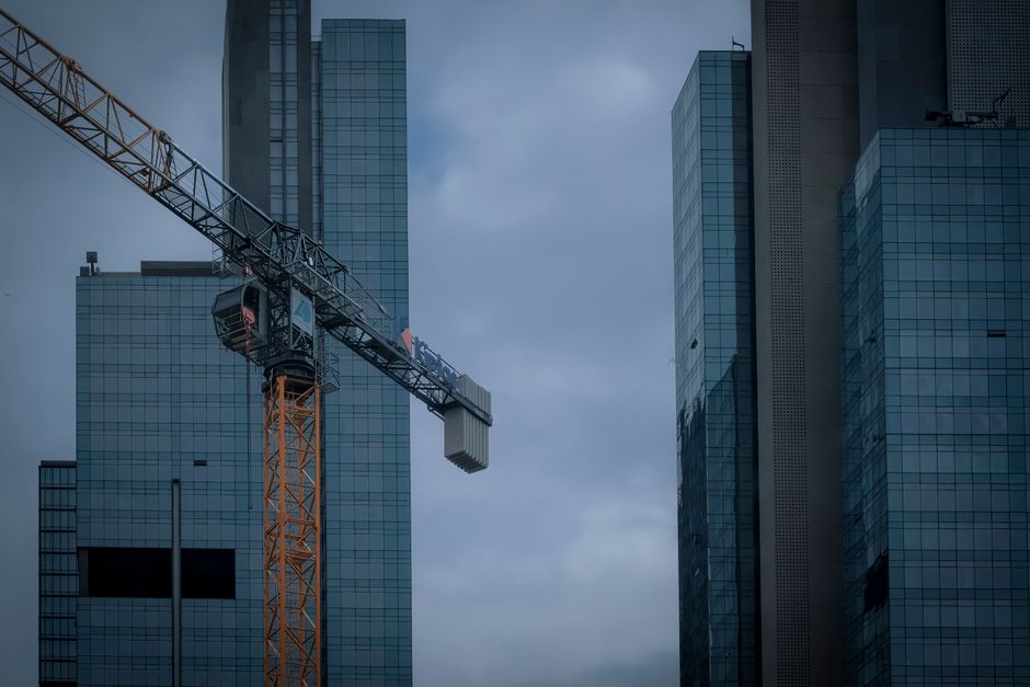 View of modern skyscrapers and construction crane under overcast skies in Istanbul.