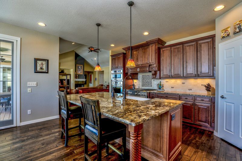 Warm wooden kitchen cabinets with granite island