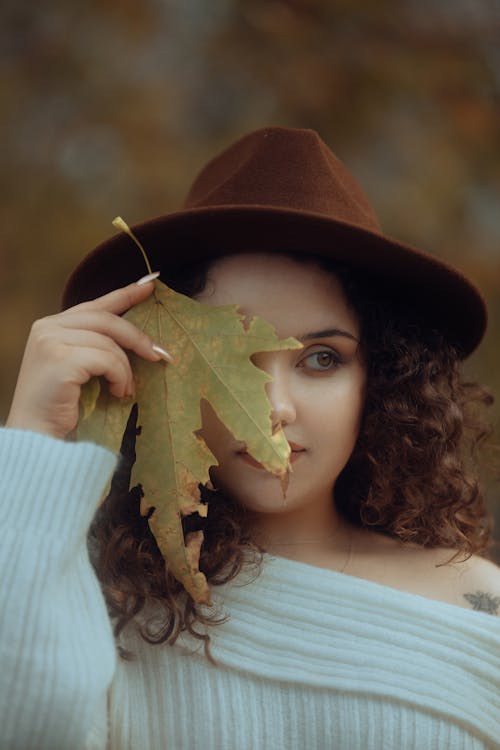 Woman in Hat Holding Leaf in Hand