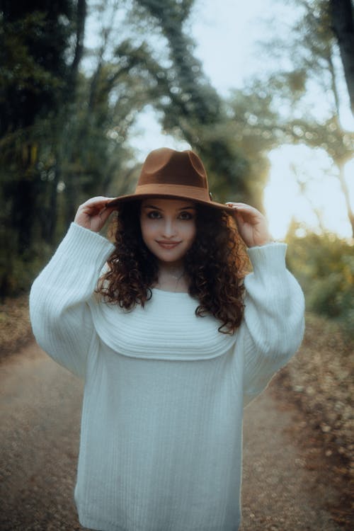 Portrait of a Pretty Brunette Wearing a White Sweater and a Fedora