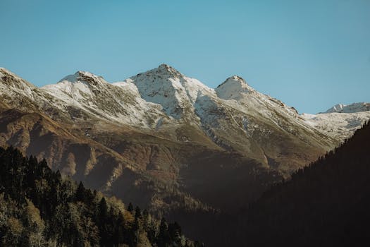 A picturesque view of snow-capped mountains under a clear blue sky.