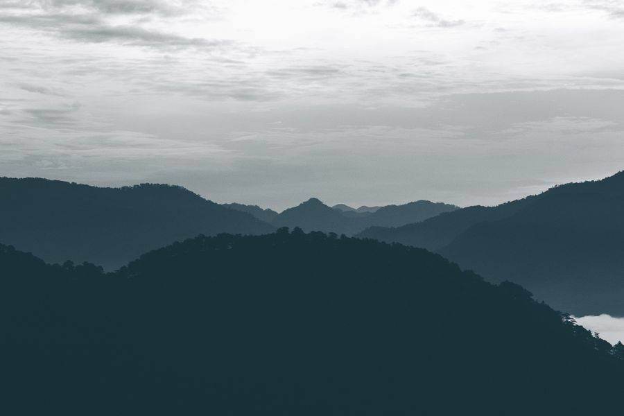 Rolling hills under a cloudy dusk sky by terence b on Pexels