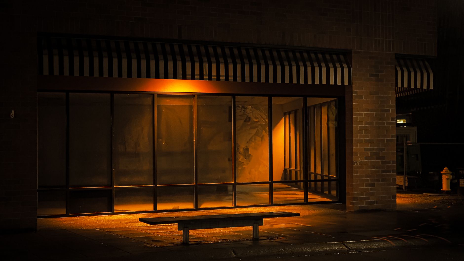 A dimly lit, empty bus stop in Redmond, WA at night, capturing urban solitude.