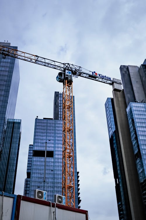 Free Low Angle Shot of Modern Skyscrapers and a Crane  Stock Photo