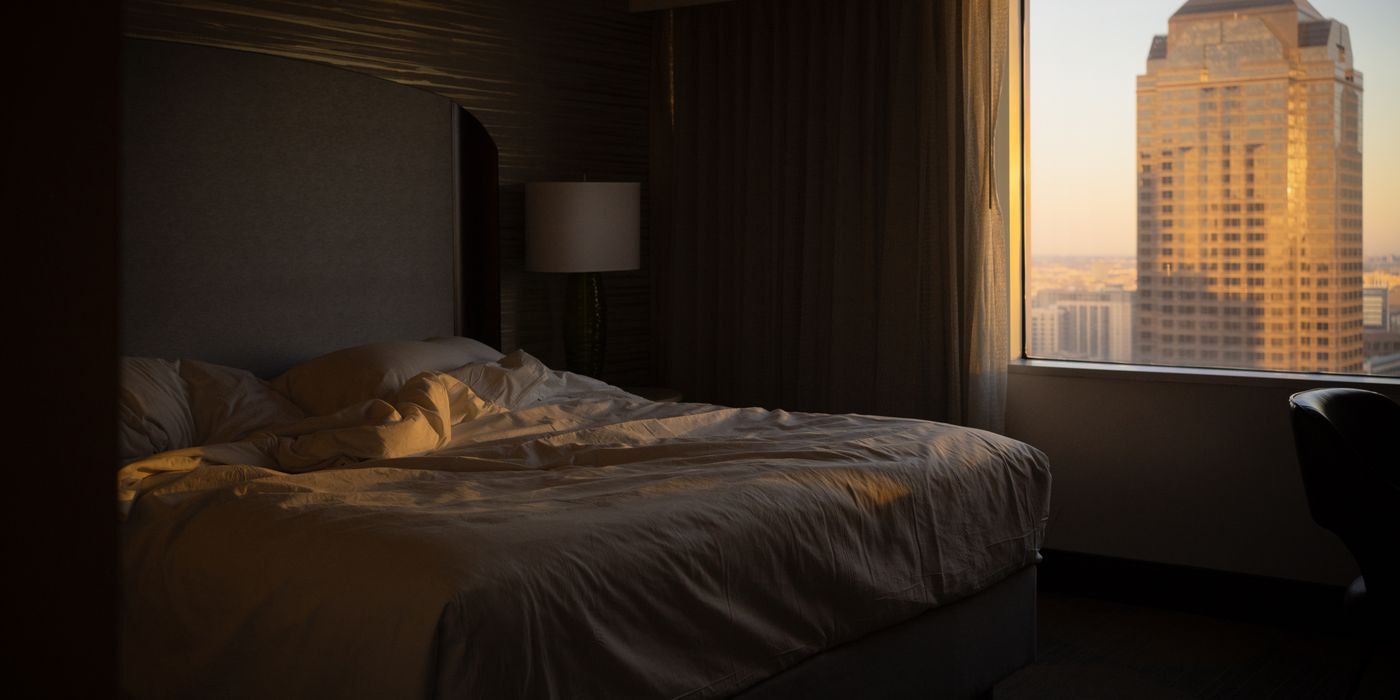 Hotel room with a large window and city view in the morning