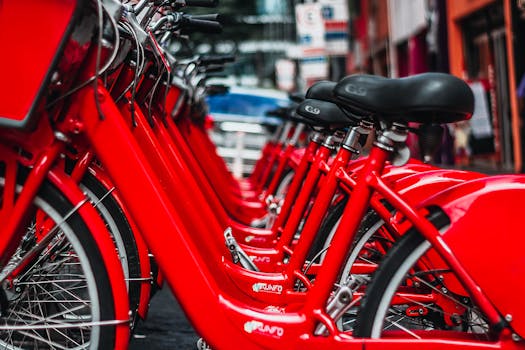 Rows of bright red bicycles parked in a bustling São Paulo street.