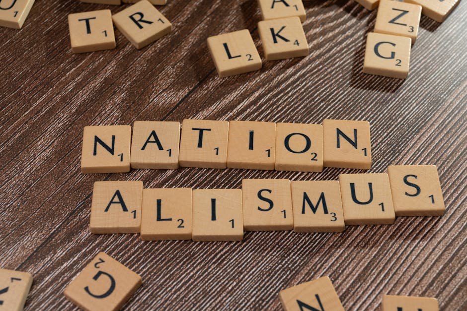 Scrabble tiles spelling 'Nationalismus' on a wooden surface, emphasizing patriotism and language concepts.