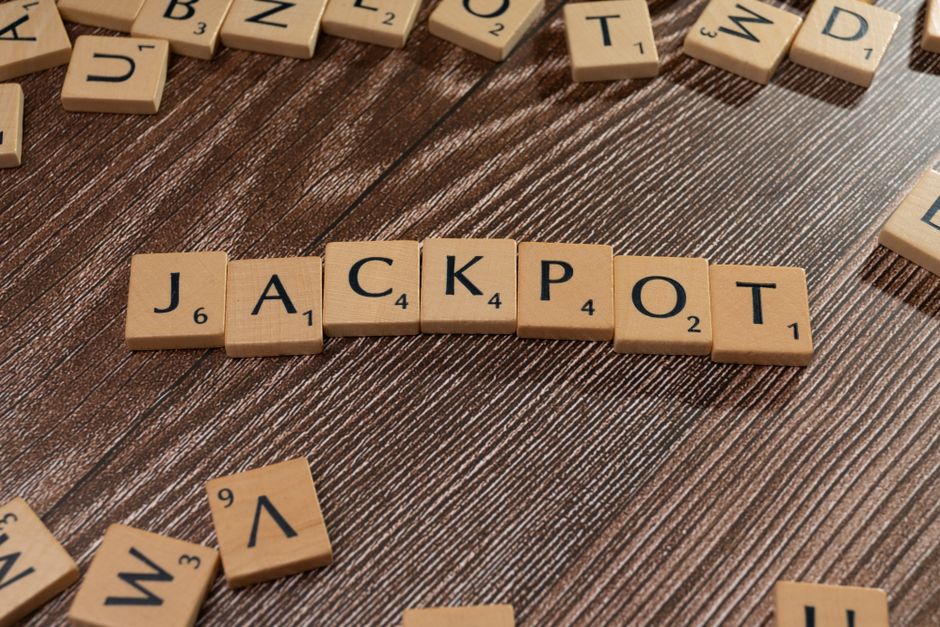 Wooden letter tiles spelling 'JACKPOT' on a textured wooden surface, representing winning or success.
