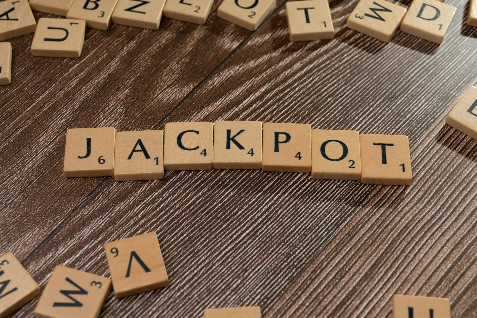 Wooden letter tiles spelling 'JACKPOT' on a textured wooden surface, representing winning or success.