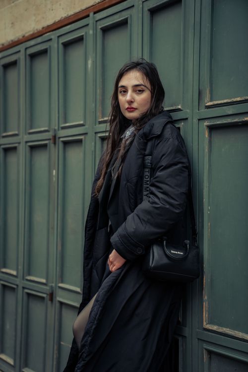 Free Fashionable woman in a long black coat posing outdoors in fall atmosphere. Stock Photo