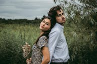 夏日，一对情侣在郁郁葱葱的草地上摆出亲密的姿势，传递着爱与温情