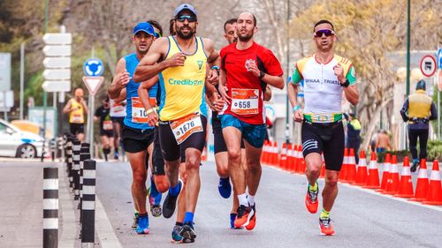 Free Dynamic scene of a group of male runners competing in an outdoor marathon. Stock Photo