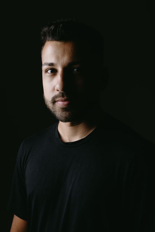 Free Close-up portrait of a bearded man in shadow against a black background, highlighting facial features. Stock Photo