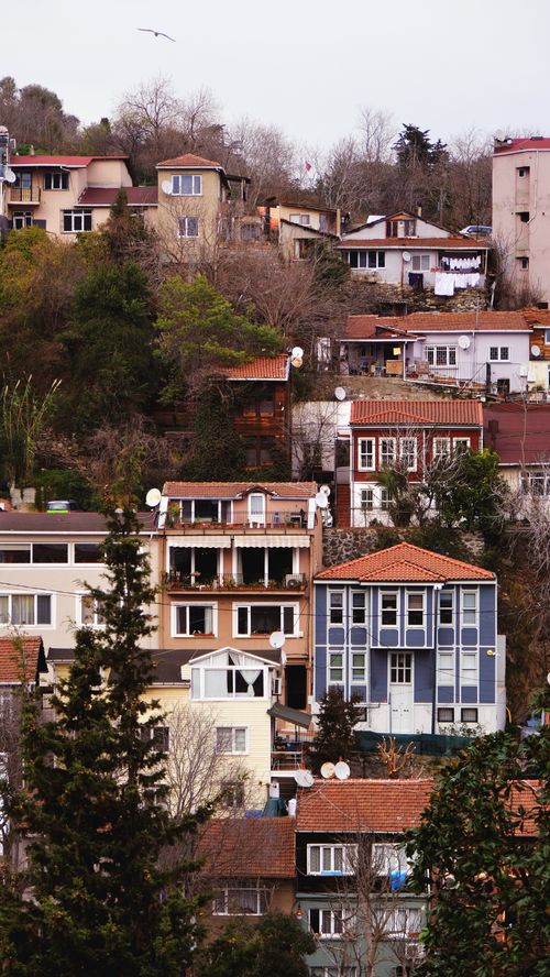 Free Aerial view of a hillside town featuring diverse architectural styles amidst lush greenery. Stock Photo