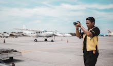 Shallow Focus Photo of Man Using Black Dslr Camera